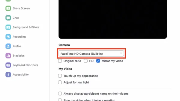 Person fixing FaceTime HD camera not working on Mac with MacBook open