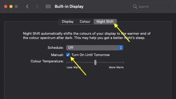 Person using MacBook adjusting Night Shift settings to reduce eye strain